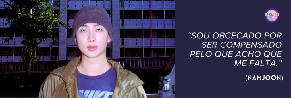 Imagem do Bangtan Now com RM (Namjoon), do BTS, em frente a um prédio moderno ao entardecer. Ele usa um gorro cinza, uma jaqueta dourada e uma camiseta escura da Nike, olhando calmamente para a câmera. No lado direito da imagem, há um fundo roxo escuro com o logo do Bangtan Now e uma citação em destaque nos tons branco e lavanda: “Sou obcecado por ser compensado pelo que acho que me falta.” (Namjoon). A imagem transmite um tom reflexivo e introspectivo, em sintonia com os temas do documentário RM: Right People Wrong Person.
