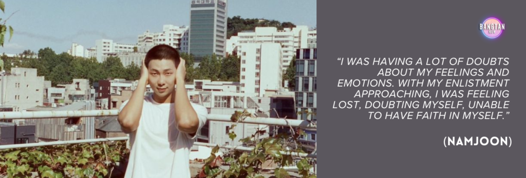 Image from Bangtan Now showing RM (Namjoon) from BTS standing on a rooftop with a cityscape of Seoul in the background, including mid-rise buildings and greenery. He is wearing a plain white T-shirt and has his hands on both sides of his head, as if expressing inner tension or deep thought. The sky is clear, contrasting with the emotional weight of the quote displayed on the right side of the image. Against a muted purple background, the text reads: “I was having a lot of doubts about my feelings and emotions. With my enlistment approaching, I was feeling lost, doubting myself, unable to have faith in myself.” (Namjoon). The Bangtan Now logo in the top right corner ties the image to the documentary "RM: Right People Wrong Person."