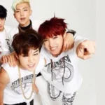 Foto promocional do photoshoot do álbum 2 Cool 4 Skool do BTS, publicada no blog Bangtan Now. A imagem apresenta os sete integrantes do grupo alinhados em frente a um fundo neutro escuro, com expressões sérias e roupas inspiradas no hip-hop underground: jaquetas pretas, bonés, correntes e acessórios marcantes. O estilo visual reflete a estética rebelde da era de estreia. No canto da imagem, aparece o Logo BTS, reforçando a identidade do grupo. A composição transmite atitude, juventude e confiança — elementos centrais da fase 2 Cool 4 Skool.