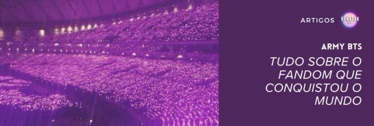 Imagem de um estádio lotado durante um show do BTS, com milhares de fãs segurando suas Army Bombs acesas, criando um imenso mar de luzes roxas. Esse efeito visual simboliza a união e força do Army BTS, um dos fandoms mais dedicados do mundo. No lado direito da imagem, há um fundo roxo com o título "Army BTS: Tudo sobre o fandom que conquistou o mundo", acompanhado do selo "Bangtan Now", reforçando a importância do fandom e sua conexão com o grupo.
