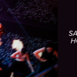 j-hope no palco durante a j-hope tour, usando calça brilhante e jaqueta aberta, cantando com intensidade enquanto dançarinos se movem ao fundo com efeitos de luz e fogo. Ao lado, o texto do artigo da Bangtan Now diz: “Saiba tudo sobre a Hope on the Stage e como ela veio para quebrar tudo!”, com o logo da Bangtan Now no topo.
