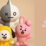 Image showing the colorful characters from BTS BT21 featured in an article on the Bangtan Now blog. From left to right and front to back, the figures include Cooky (pink bunny), Chimmy (yellow puppy), Tata (red heart-headed alien), Mang (masked dancer), Koya (blue koala), RJ (white alpaca), Shooky (cookie), and Van (gray and white space robot). The right side of the image displays the Bangtan Now logo and the article title: "BTS BT21 – Discover the fun and exciting world of the characters created by BTS."