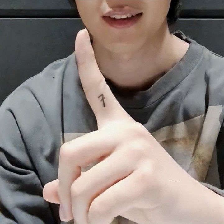 BTS Tatoos - Bangtan Now (2) Close-up of BTS member Jimin during a Weverse live, holding up his right index finger to show his small “7” tattoo on the inner side. The tattoo is part of the BTS friendship tattoos shared by all members. This moment is featured in a Bangtan Now article about BTS Tattoos, highlighting the personal placement choices and meanings behind each member’s design.