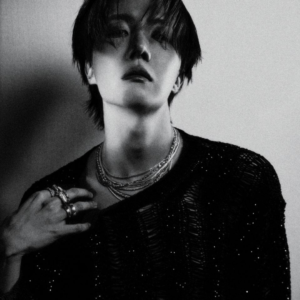 j-hope en una concept photo oficial de la música Killin it Girl, destacada en el artículo de Bangtan Now. En blanco y negro, aparece con expresión seria y cabello mojado, usando un suéter texturizado y varios collares y anillos brillantes. La imagen transmite una mezcla de sensualidad, elegancia y poder, reflejando el espíritu visual de esta era.