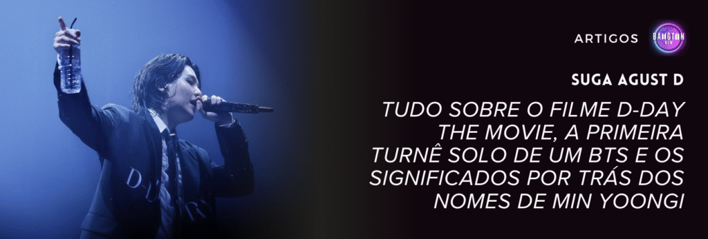 SUGA Agust D, membro do BTS, em momento de performance ao vivo durante show da turnê mundial D-Day Tour. Ele veste terno preto de alfaiataria da marca Valentino, tem cabelo preto molhado caindo sobre o rosto, segura garrafa de água mineral transparente erguida com a mão esquerda em gesto expressivo enquanto canta ao microfone. O palco está envolvido em iluminação azul dramática que cria contraste e atmosfera emocional intimista. À direita da imagem aparece o logotipo do Bangtan Now e o título do artigo em fonte branca itálica.