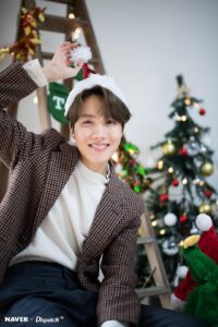 j-hope brilha como sempre, agora em versão Natalino Chique™, misturando elegância com uma pitada de caos festivo. Com blazer de padronagem retrô, suéter branco e um gorro de Papai Noel em miniatura equilibrado na cabeça como se fosse acessório fashion, ele sorri como quem já dominou a arte de espalhar alegria com um aceno. Ao fundo, temos árvore decorada, luzes, meias penduradas e até uma escadinha metida a Pinterest. É BTS em clima de festa, e ele claramente entendeu a missão. Especial para o Naver em artigo do Bangtan Now. BTS Natal.