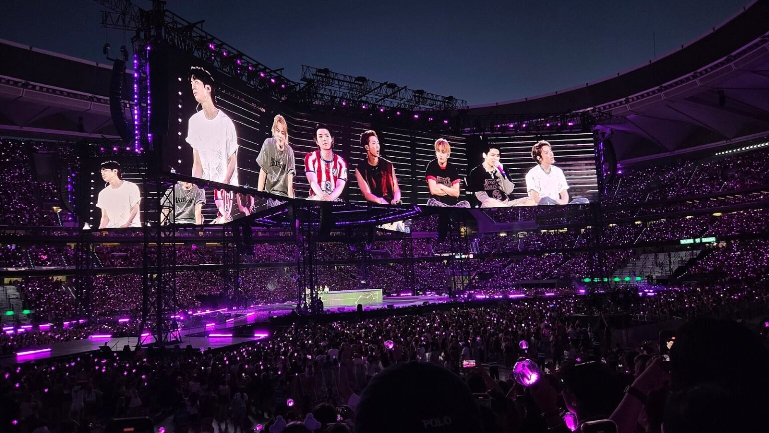 Estádio lotado com luzes roxas no show da turnê Arirang do BTS em Madri