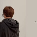 Namjoon's exhibition at SFMOMA: Namjoon, seen from behind, next to the big signature he left on the museum wall (photo shared by RM on Instagram stories)